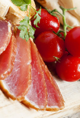 Pork smoked ham and tomatoes on the board, selective focus