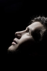 Man side profile portrait looking up lighted on a half face