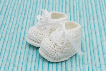 White Baby Booties on wood background