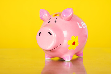 Piggy coin bank on yellow background 