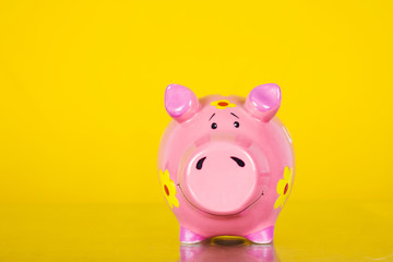 Piggy coin bank on yellow background 