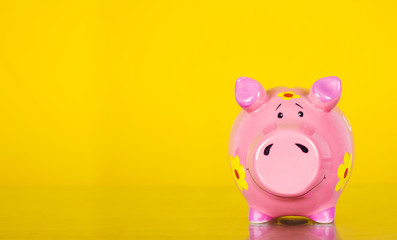 Piggy coin bank on yellow background 