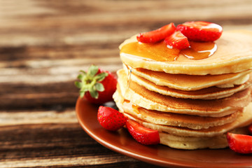 Delicious pancakes with strawberry on brown wooden background