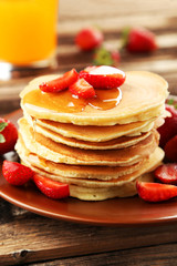 Delicious pancakes with strawberry on brown wooden background