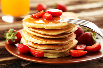 Delicious pancakes with strawberry on brown wooden background