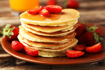 Delicious pancakes with strawberry on brown wooden background