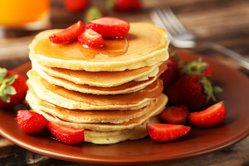 Delicious pancakes with strawberry on brown wooden background