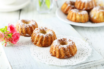 Bundt cakes on cutting board on white wooden background
