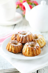 Bundt cakes on plate on white wooden background