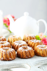 Bundt cakes on cutting board on white wooden background