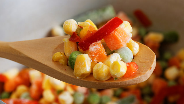Closeup spoon with frozen mixed vegetables
