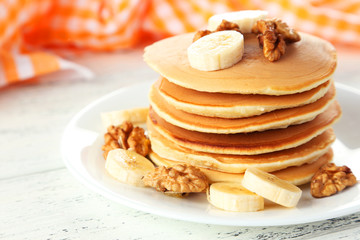 Fototapeta na wymiar Delicious pancakes with banana on white wooden background
