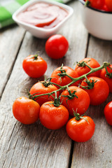 Fresh cherry tomatoes on grey wooden background