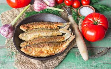 Fried fish and vegetables on the table. Rustic style