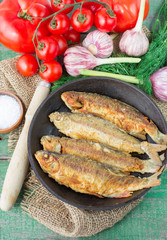 Fried fish and vegetables on the table. Rustic style