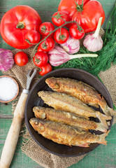 Fried fish and vegetables on the table. Rustic style