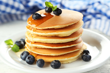 Delicious pancakes with blueberries on white wooden background