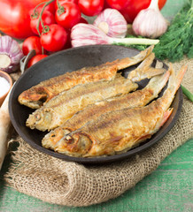 Fried fish and vegetables on the table. Rustic style