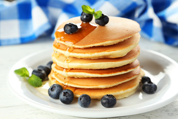 Delicious pancakes with blueberries on white wooden background