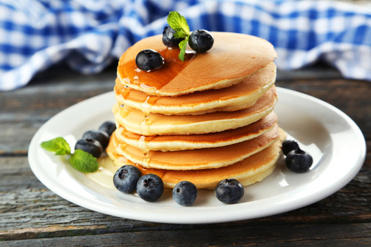 Delicious pancakes with blueberries on blue wooden background