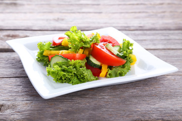 Fresh vegetable salad on grey wooden background