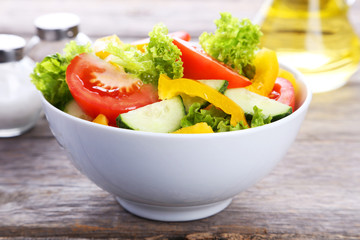 Fresh vegetable salad on grey wooden background