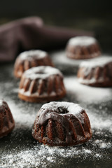 Chocolate bundt cakes with icing sugar on black background