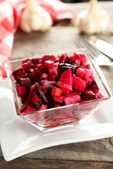 Beetroot salad in clear bowl on grey wooden background