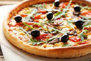 Fresh tasty pizza on brown wooden background