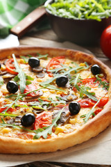 Fresh tasty pizza on brown wooden background