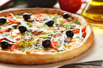 Fresh tasty pizza on brown wooden background