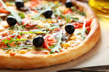 Fresh tasty pizza on brown wooden background