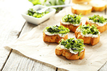 Tasty fresh bruschetta on parchment on grey wooden background