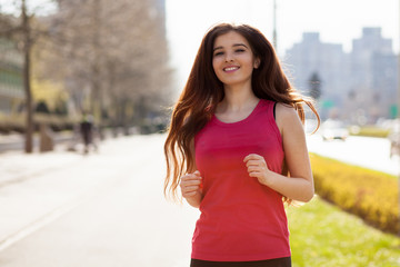 Young beautiful woman running in the city