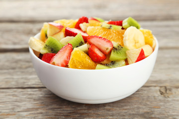 Fresh fruit salad on grey wooden background
