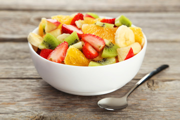 Fresh fruit salad on grey wooden background