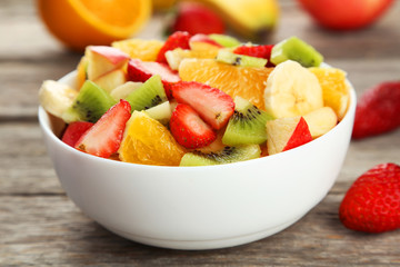 Fresh fruit salad on grey wooden background