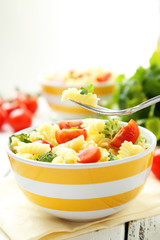 Delicious pasta in bowl on white wooden background