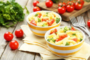 Delicious pasta in bowl on grey wooden background