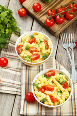 Delicious pasta in bowl on grey wooden background