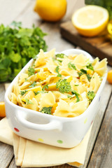 Delicious pasta with with broccoli in bowl on grey wooden backgr