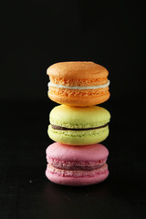 French colorful macarons on black background