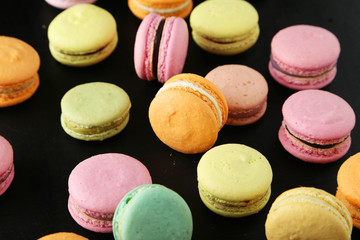 French colorful macarons on black background