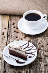 Chocolate dessert with coffee cup and coffee beans on wooden bac