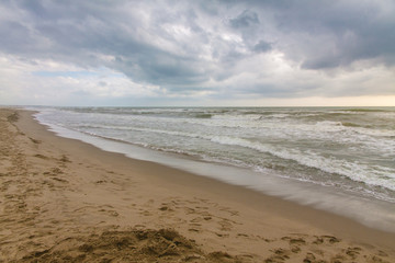 Empty beach and waves  in a cloudy day