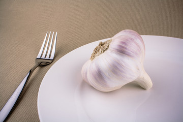 Garlic on white plate with fork