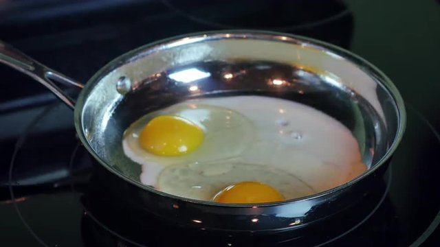 Timelapse of two eggs cooking in frying pan, 4K