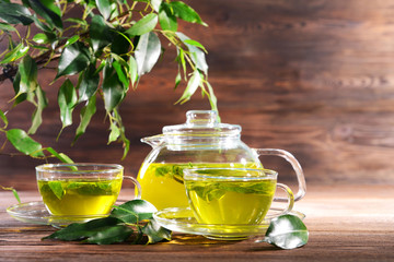Cups of green tea on table on wooden background