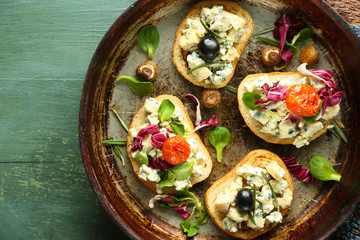 Tasty sandwiches on old pan, on wooden table
