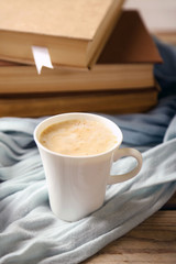 Still life with cup of coffee and books, on wooden table